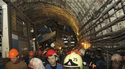 Miembros de los servicios de rescate junto a los restos del convoy que descarriló en el metro de Moscú.