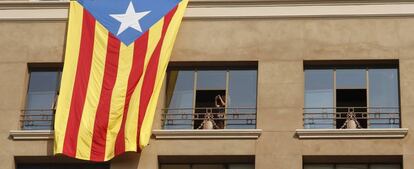 Una estelada cuelga sobre un edifico de Barcelona.