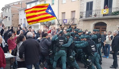 Fotomontaje difundido por usuarios de Twitter en el que se muestra a la Guardia Civil confrontándose a votantes que portan una estelada frente a un colegio electoral en la calle.