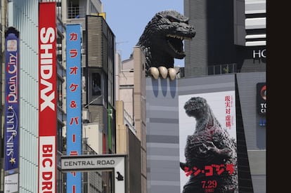 Cartel de 'Nuevo Godzilla' bajo la cabeza del monstruo de la película, en un cine de Tokio (Japón).