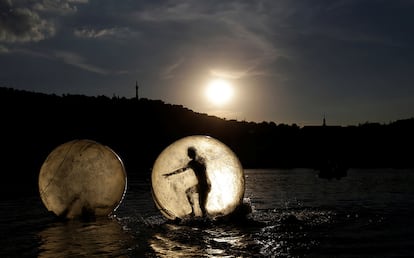 Varias personas juegan dentro de bolas de plástico gigantes, llamadas Zorb, en el río Vltava de Praga (República Checa).