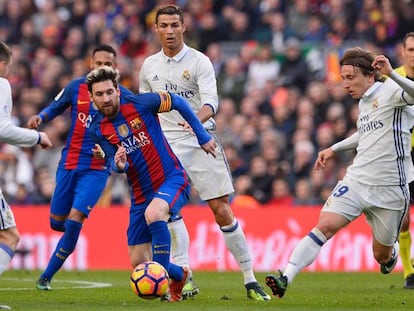 Leo Messi lleva el bal&oacute;n ante Cristiano Ronaldo y Luka Modric, en un Barcelona-Real Madrid de La Liga espa&ntilde;ola.