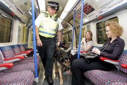 Un policía patrulla con su perro en un vagón de metro al pasar por la estación de Russell Square, que ayer se reabrió al público.