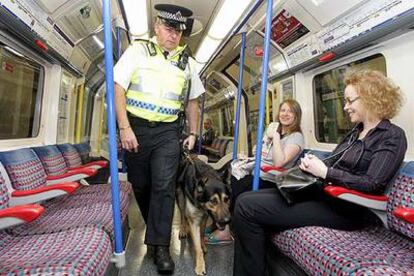 Un policía patrulla con su perro en un vagón de metro al pasar por la estación de Russell Square, que ayer se reabrió al público.