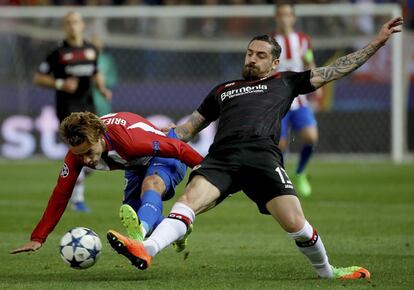 El delantero francés del Atlético de Madrid Antoine Griezmann (i) lucha el balón con Roberto Hilbert, defensa del Bayer Leverkusen.