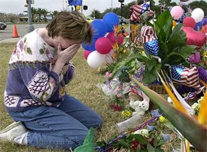 Una mujer llora tras dejar siete rosas y globos en el Johnson Space Center de Houston (EE UU) en honor a los fallecidos.