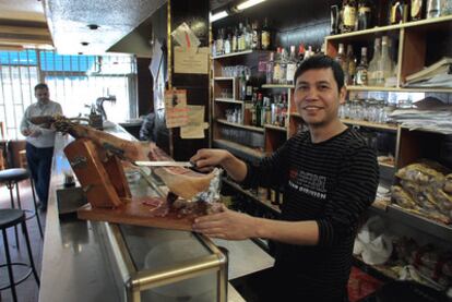 Jiang Yong Liang, <i>Julián</i>, un hostelero chino de 34 años, demuestra en su bar "lo bien" que se le da cortar el jamón.