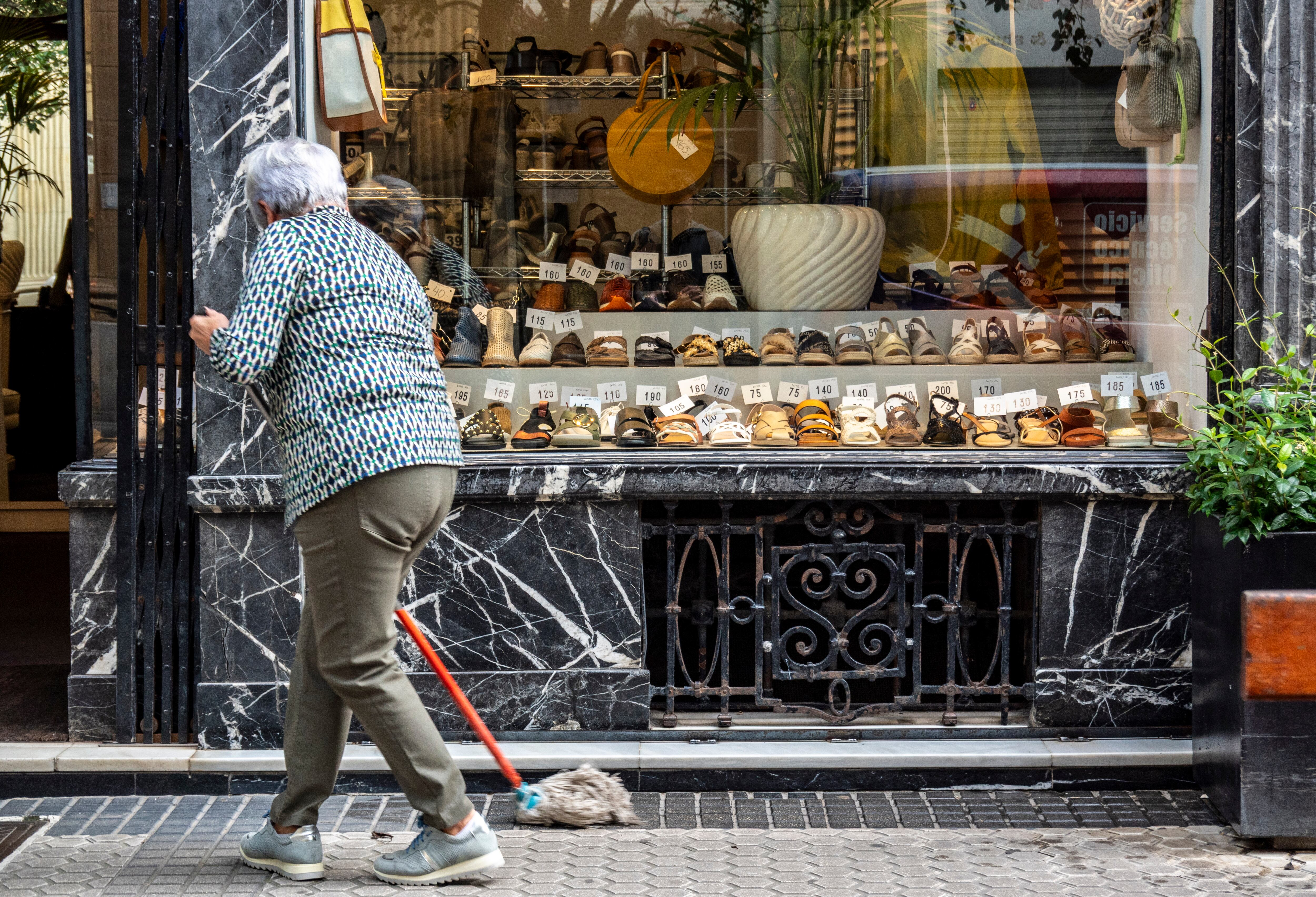Una mujer limpia junto a su comercio en San Sebastián (Guipuzcoa).