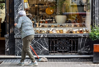 Una mujer limpia junto a su comercio en San Sebastián (Guipuzcoa).