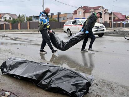 Voluntarios retiran en bolsas los cadaveres de civiles asesinados durante el bombardeo ruso a la ciudad de Bucha, cerca de Kiev.