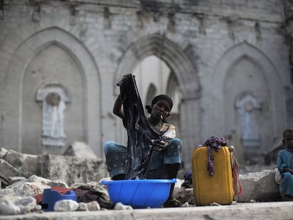 Una mujer lava la ropa sentada entre las ruinas de una antigua catedral católica en Mogadiscio (Somalia), al huir de su casa por la peor sequía de los últimos 60 años en el Cuerno de África.