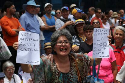 Una mujer sostiene mensajes de protesta contra los resultados electorales. 