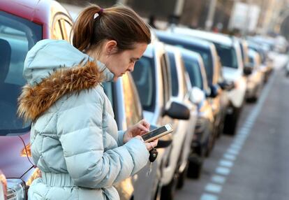 Una mujer utiliza una aplicaci&oacute;n m&oacute;vil para pagar el estacionamiento en la zona SER.