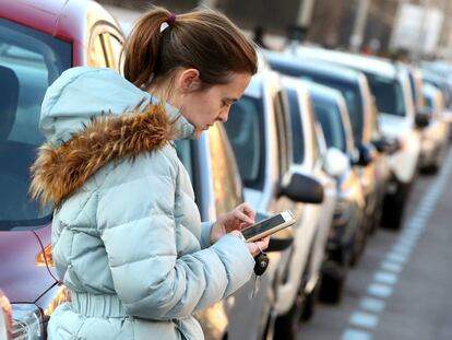 Una mujer utiliza una aplicaci&oacute;n m&oacute;vil para pagar el estacionamiento en la zona SER.