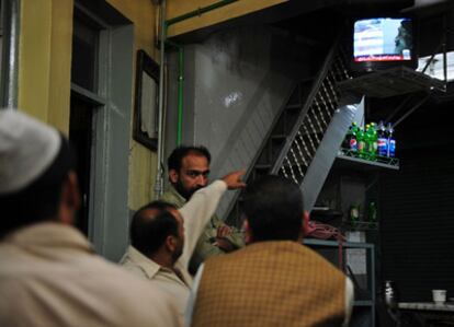 Parroquianos de Abbottabad ven por televisión las imágenes difundidas por el Gobierno de EE UU de vídeos caseros de Osama bin Laden decomisadas en su complejo