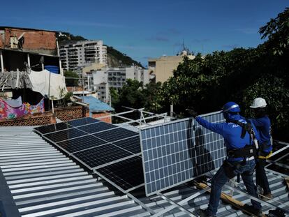 Trabajadores de la organización sin fines de lucro Revolusolar instalan paneles solares en una favela en Río de Janeiro (Brasil), el pasado 1 de marzo.