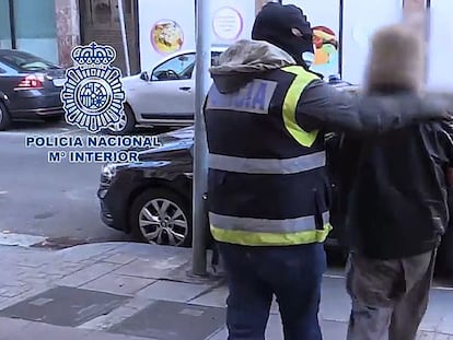 Agentes de la Policía Nacional custodian a uno de los detenidos.