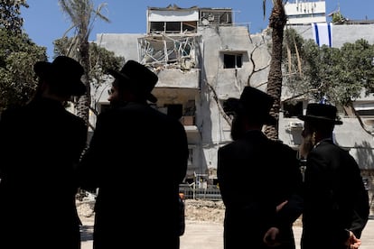 Hombres judíos ultraortodoxos observan un edificio en ruinas tras un ataque iraní en Haifa (Israel).
