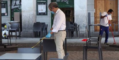 Un camarero comprueba la distancia entre mesas en la terraza de su bar de la Plaza Mayor en Madrid este lunes, primera jornada de la fase 1.