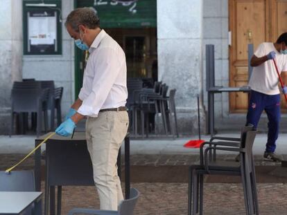 Un camarero comprueba la distancia entre mesas en la terraza de su bar de la Plaza Mayor en Madrid este lunes, primera jornada de la fase 1.