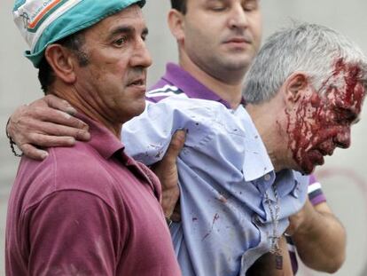 El maquinista Francisco José Garzón es ayudado por dos vecinos de Angrois tras el accidente.