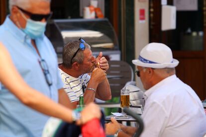 Personas fumando en terrazas y vías públicas en Málaga.