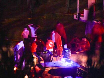 Varios miembros de la Guardia Civil y voluntarios de Cruz Roja atienden a un grupo de marroquíes en Ceuta.