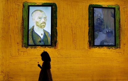Una niña pasa junto a una pantalla en el estreno mundial de la exposición 'Encuentro Vicent van Gogh' en Pekín, China.