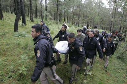 Los equipos de rescate transportan uno de los cadáveres recuperados en la zona del siniestro del helicóptero.