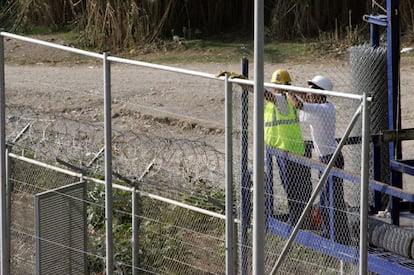 Unos operarios trabajan en la valla para subirla de altura en el lugar donde saltaron los subsaharianos.