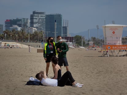 Dos trabajadores del Ayuntamiento de Barcelona controlan el aforo de la playa del Bogotell, este jueves.