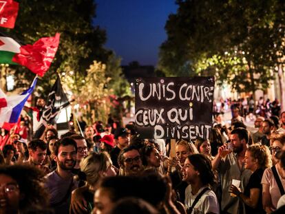 Una joven sostiene una pancarta que reza "Unidos contra los que nos dividen", tras la victoria de la izquierda en la segunda vuelta de las elecciones legislativas francesas, en Marsella, este domingo.