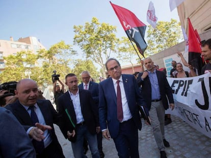 Quim Torra pasa junto a una protesta de profesores en Barcelona.