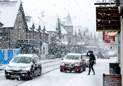 Un viandante camina por la nieve durante una tormenta de nieve en Pitlochry, Escocia.