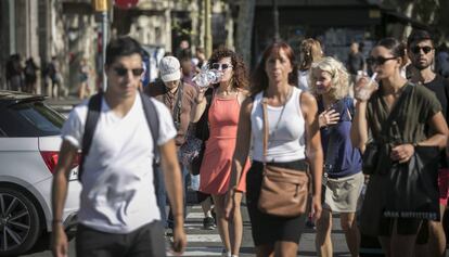 Ciudadanos refrescándose en Barcelona por el calor.