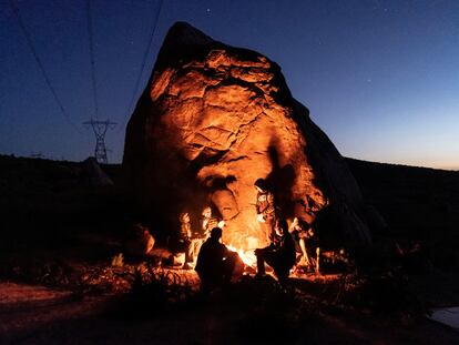 Migrantes de la India y Colombia esperan a la patrulla fronteriza alrededor de una fogata, en abril de 2024 en Jacumba (California).