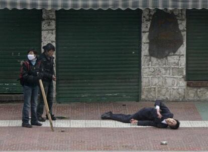 Un tibetano yace herido en la calle tras los enfrentamientos con la policía china en el centro de Lhasa, ayer.