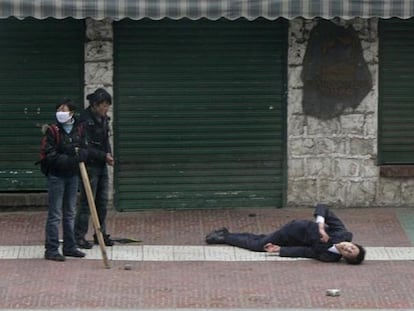 Un tibetano yace herido en la calle tras los enfrentamientos con la policía china en el centro de Lhasa, ayer.