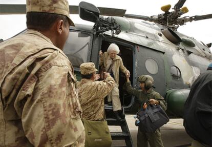 Los soldados peruanos ayudan a una mujer a bajar del helicóptero en Cuzco.