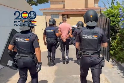 Uno de los dos detenidos es conducido por agentes de Policía Nacional en Benidorm.