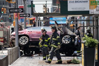 Bomberos junto al coche en un cruce en Times Square.