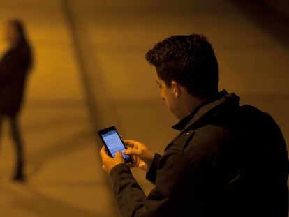 Un joven comprueba su teléfono movil.