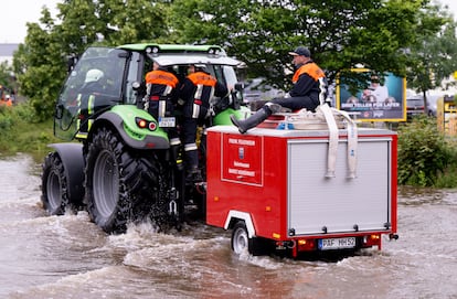 Un equipo de bomberos conducen un tractor en una carretera inundada, este domingo en Reichertshofen, Baviera.