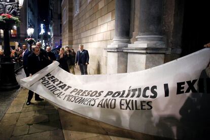 El presidente de la Generalitat, Quim Torra, a la izquierda, muestra la pancarta por la que la Junta Electoral Central le ha sancionado, ordenando que se le retire su credencial de diputado autonómico, lo que conlleva su inhabilitación, el 3 de enero de 2020.