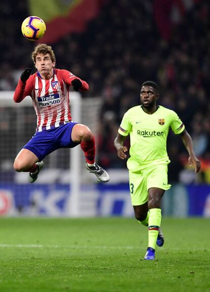 El delantero francés del Atlético de Madrid Antoine Griezmann, cabecea el balón junto al defensor francés de Barcelona Samuel Umtiti.
