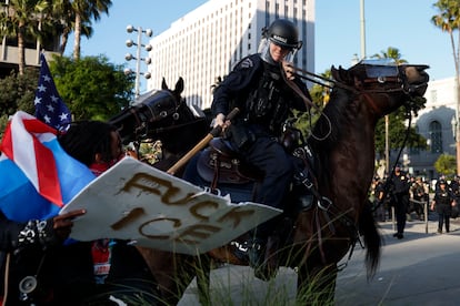 A police officer confronts protesters outside Los Angeles City Hall on June 11.
