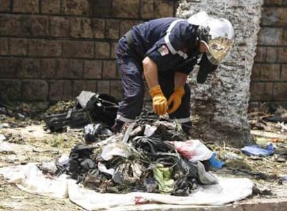 Un efectivo de los servicios de emergencias inspecciona el lugar donde esta mañana se ha registrado un atentado suicida cerca de Argel.