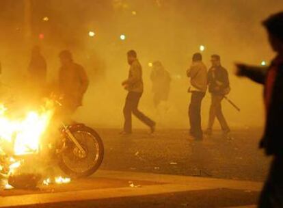 Los antidisturbios han tenido que usar gases lacrimógenos para dispersar a los manifestantes en París. La imagen muestra a varios jóvenes alrededor de una motocicleta ardiendo.