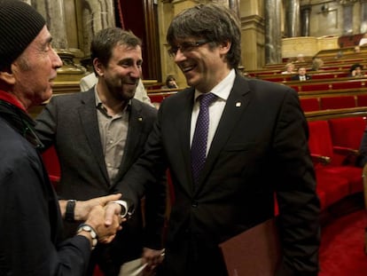 Llach (i) y Puigdemont se dan la mano en presencia de Com&iacute;n.