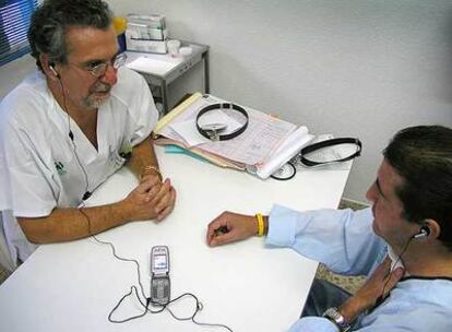 Un médico y un paciente se comunican por el sistema de teletraducción.